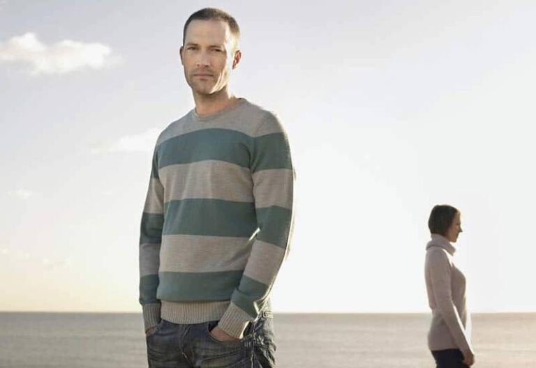 man wearing sweatshirt standing against the woman