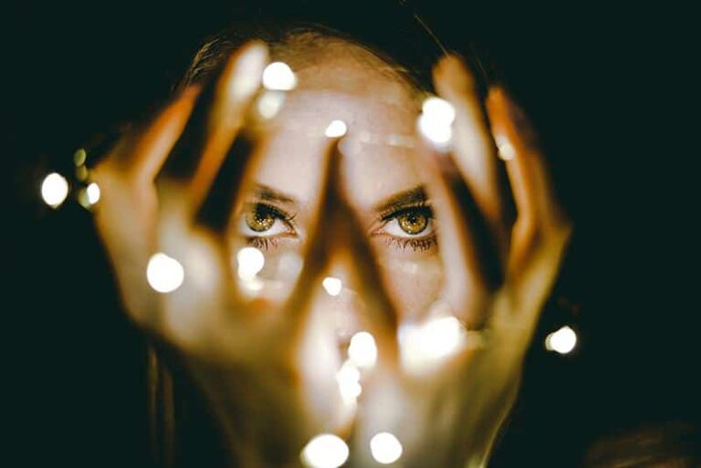 retrato de mujer ojos grandes marrones a través de los dedos