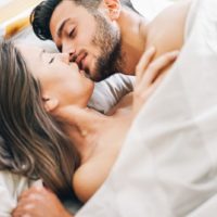 passionate couple kissing in bed