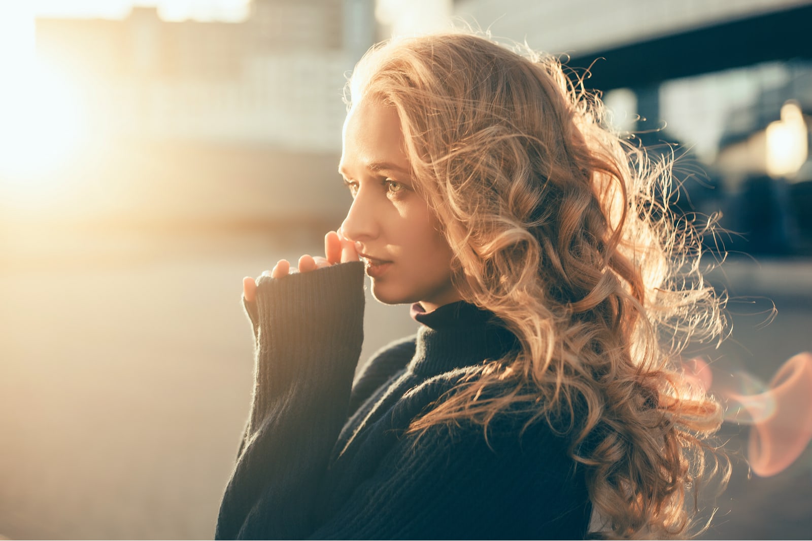 una rubia hermosa y triste está fuera al atardecer