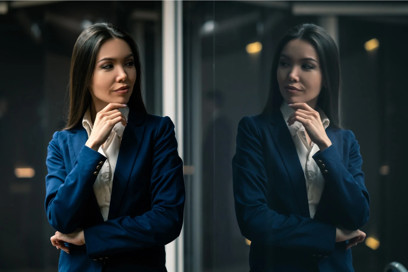 a determined businesswoman looks at herself in the glass with a smile