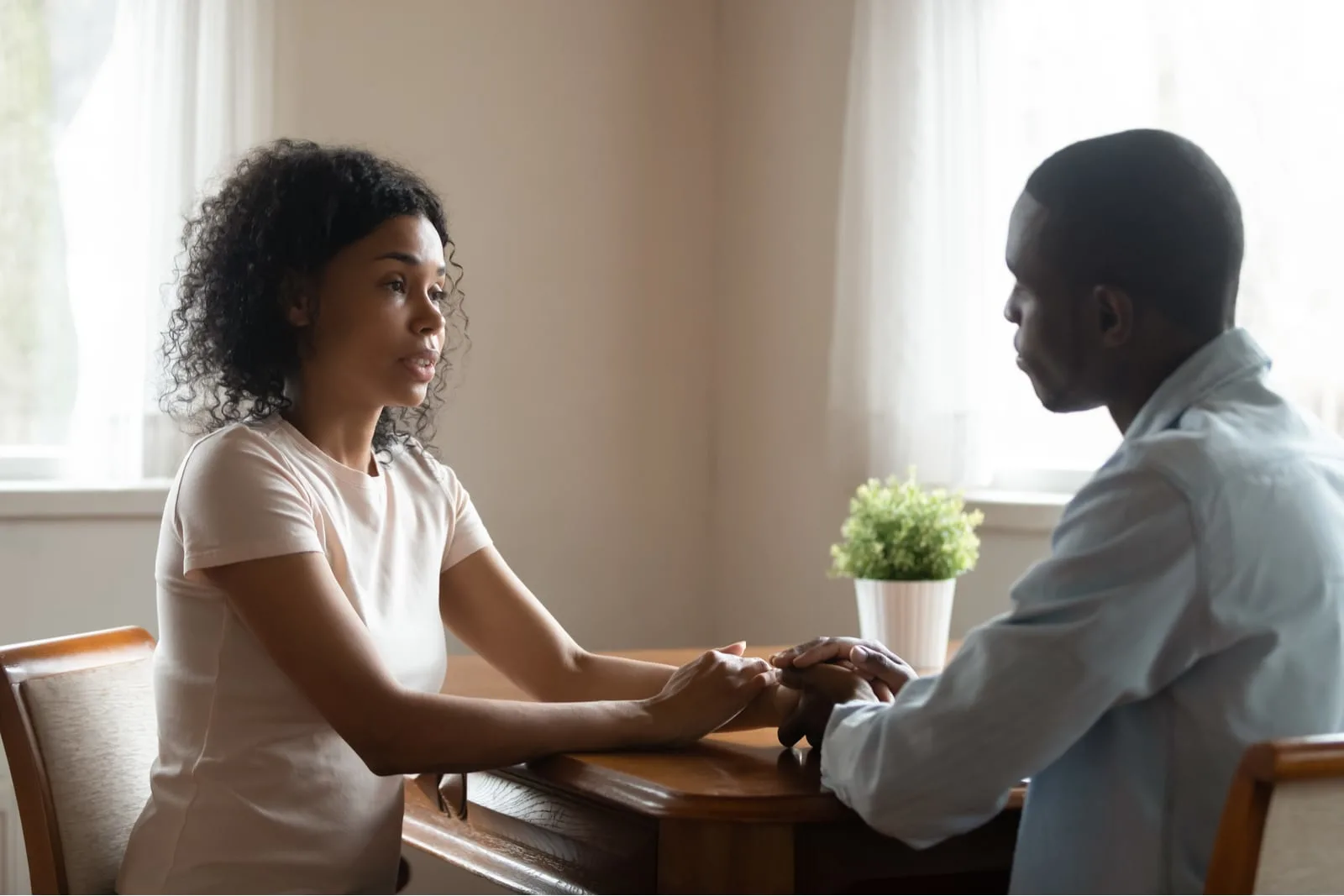 a sad black woman is talking at home with her man