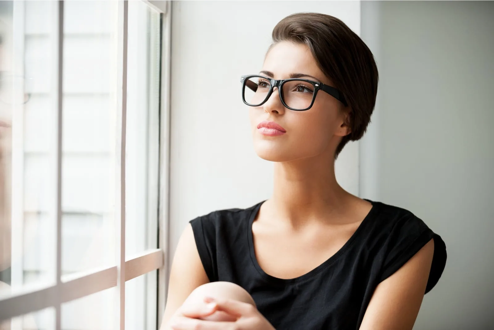 attractive brunette with glasses sitting and thinking