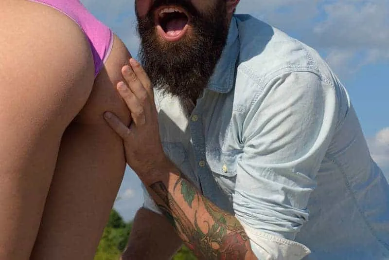 bearded man grabs woman's butt