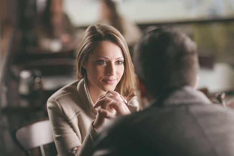 beautiful brunette staring at man in cafe