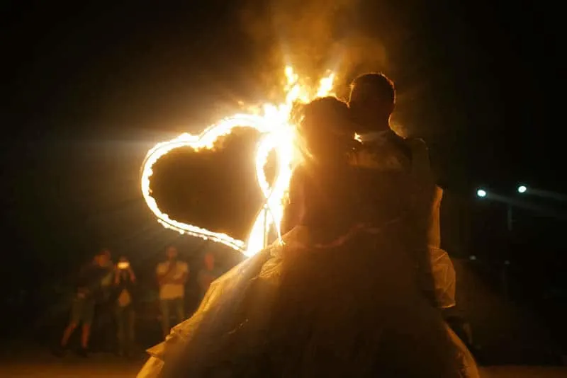 bride hugging while holding fire shape of heart