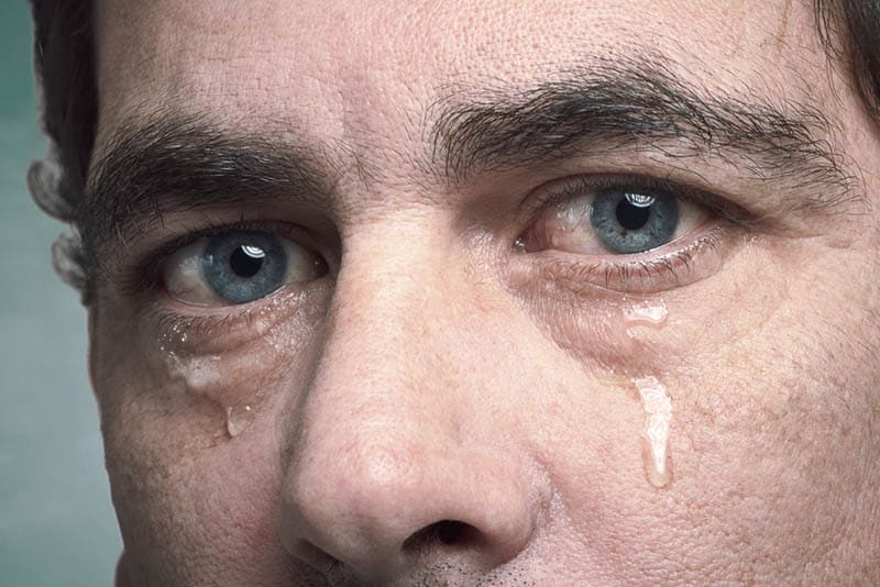 close-up photo of crying man with blue eyes