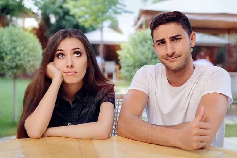 confused couple sitting at table