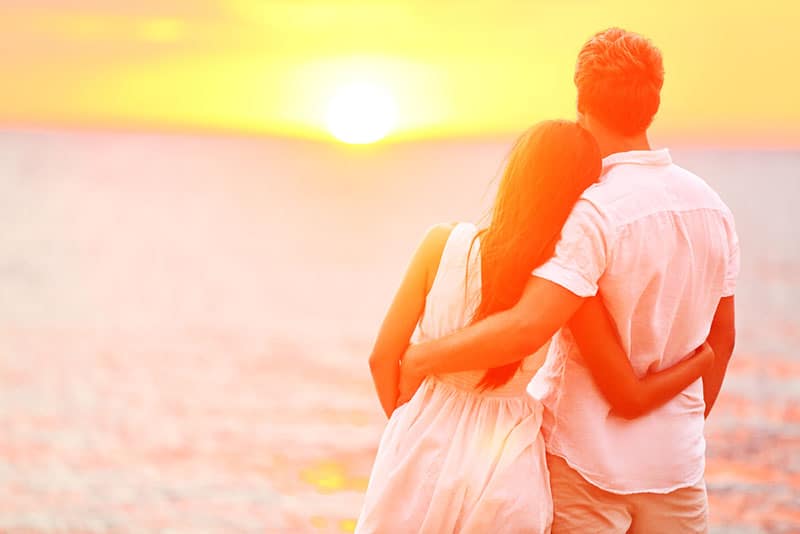 couple in hug standing in the sunset