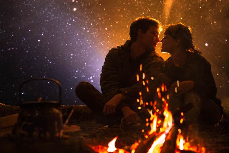 couple sitting in front of bonfire