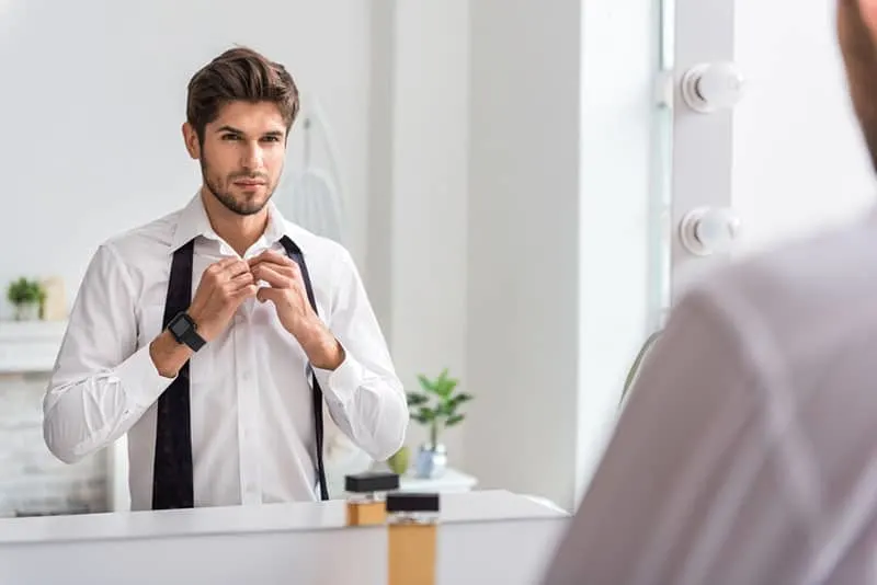 handsome man looking at mirror