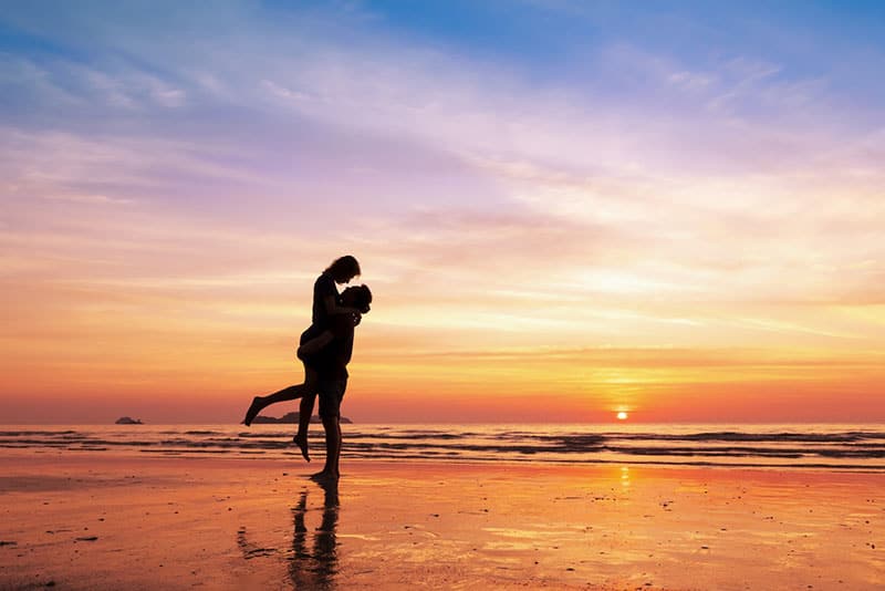 happy couple on the beach at sunset