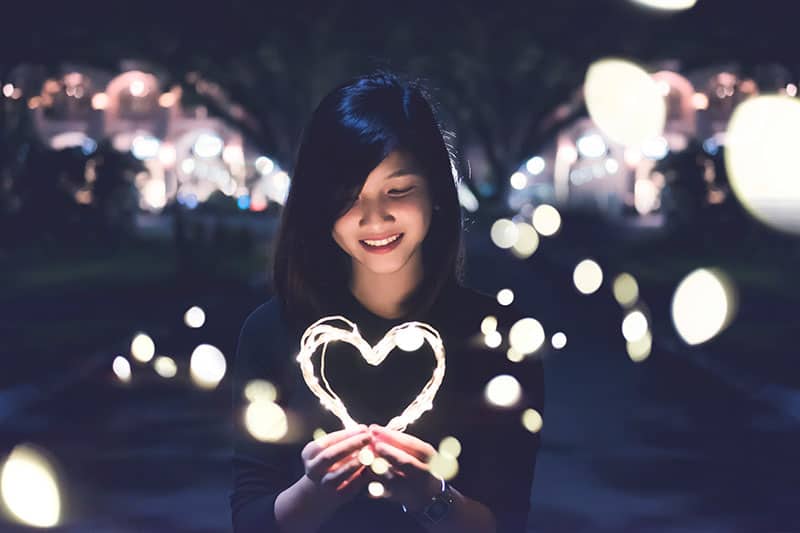 happy woman holding a heart of light