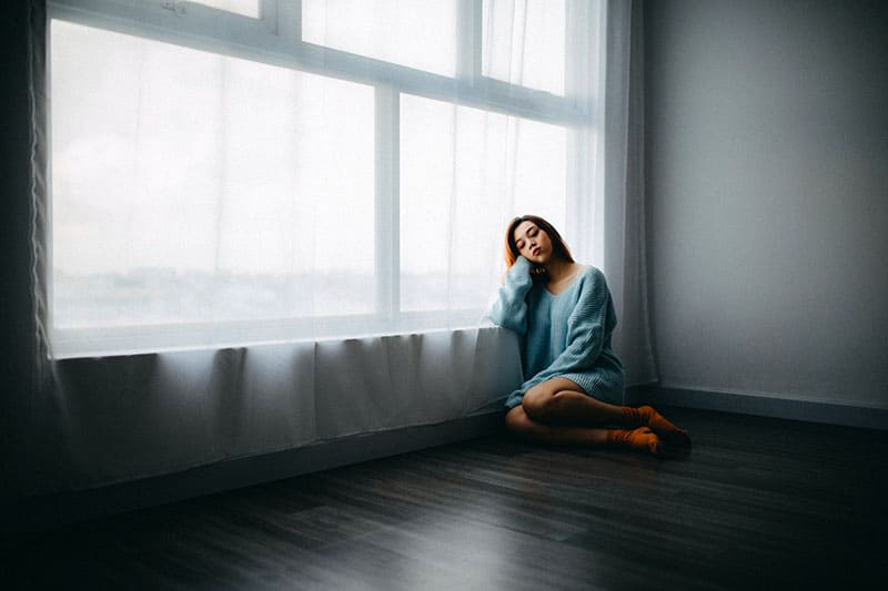 lonely woman sitting in the room on the floor