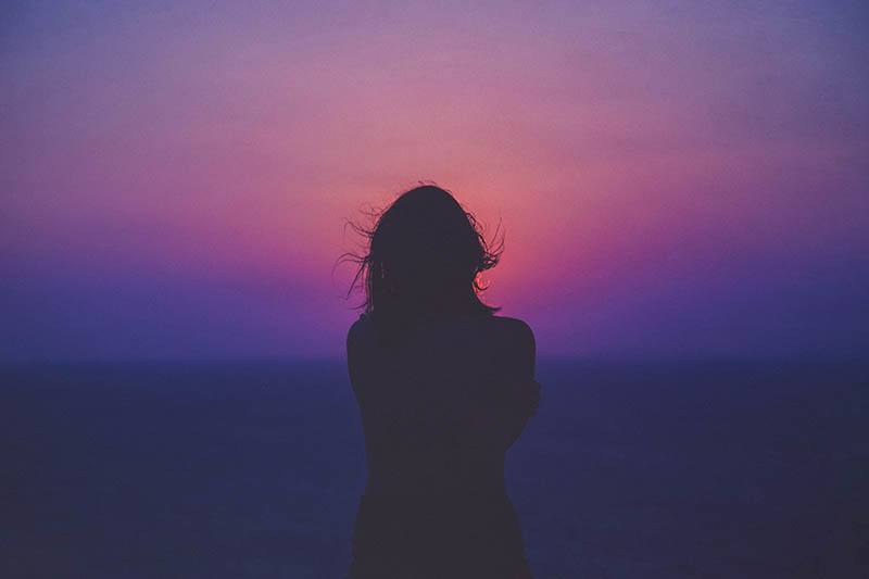 lonely woman standing in purple light