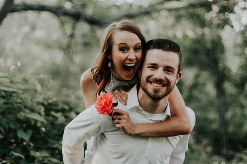 man holding woman on back