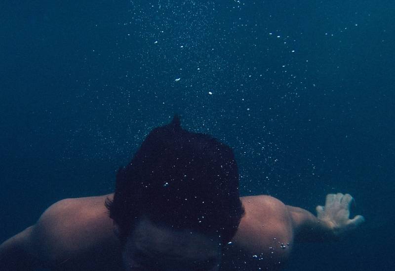 uomo immerso in uno specchio d'acqua