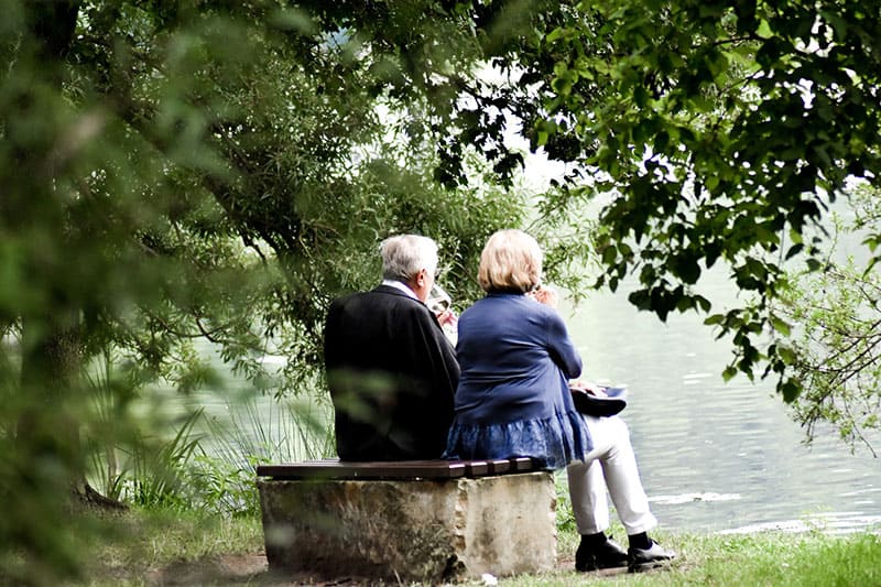 old couple sitting on the bench in the park