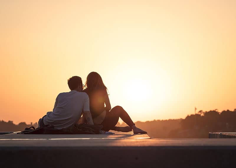 pareja romántica viendo la puesta de sol