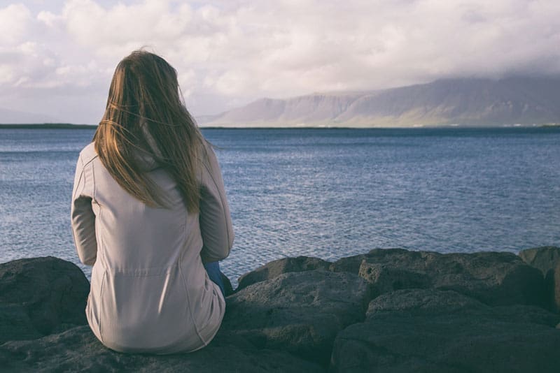 ledsen kvinna som tittar på havet