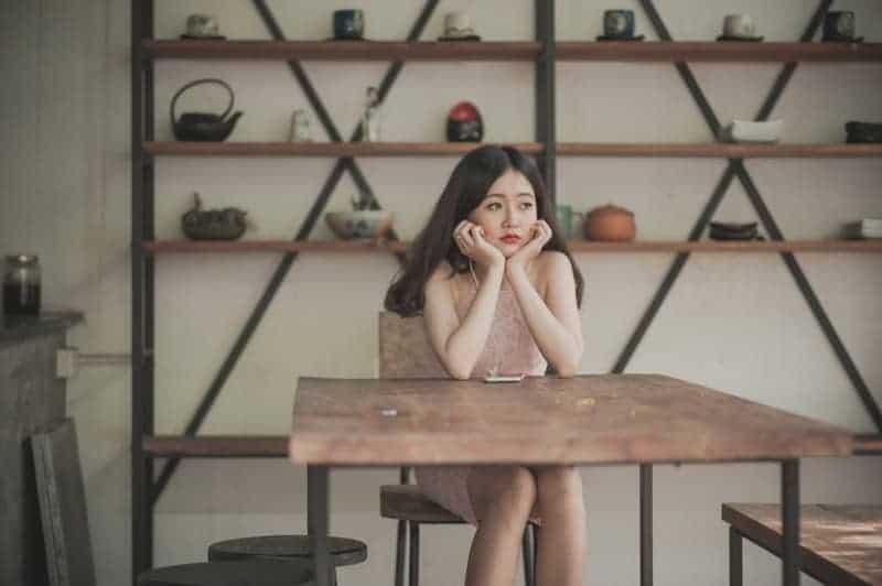 mujer triste sentada junto a la mesa