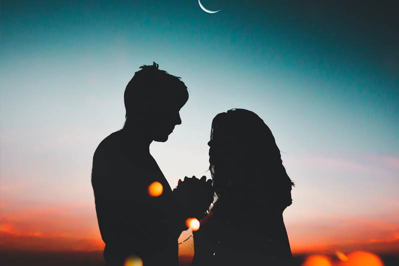 silhouette of couple standing in front of each other