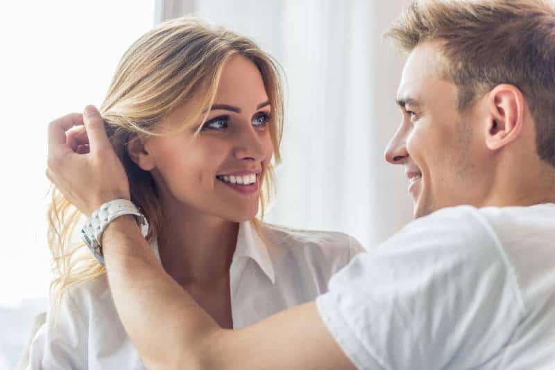 pareja sonriente mirándose en casa