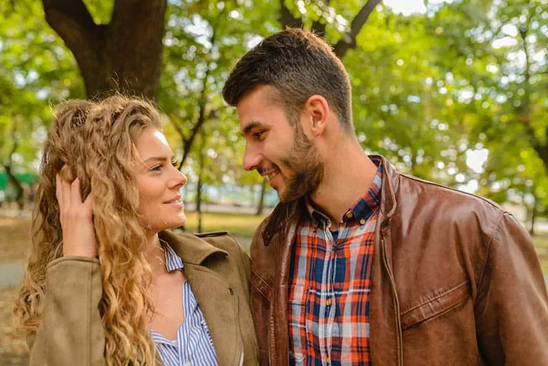 smiling man and woman looks at each other eyes