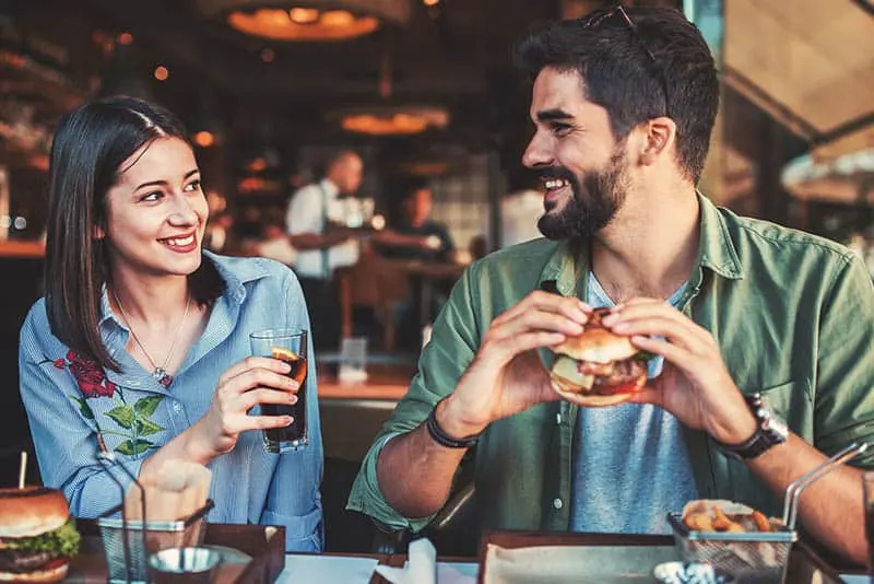 smiling young couple looking each other in restaurant