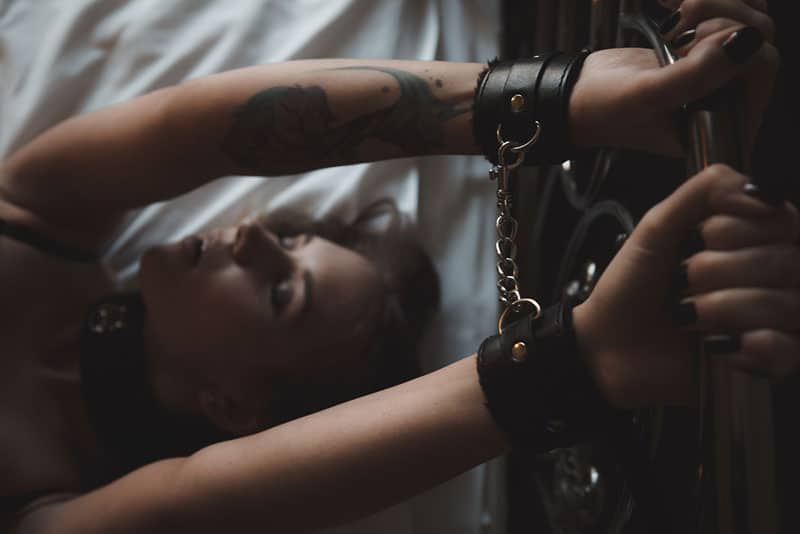 woman handcuffed on bed