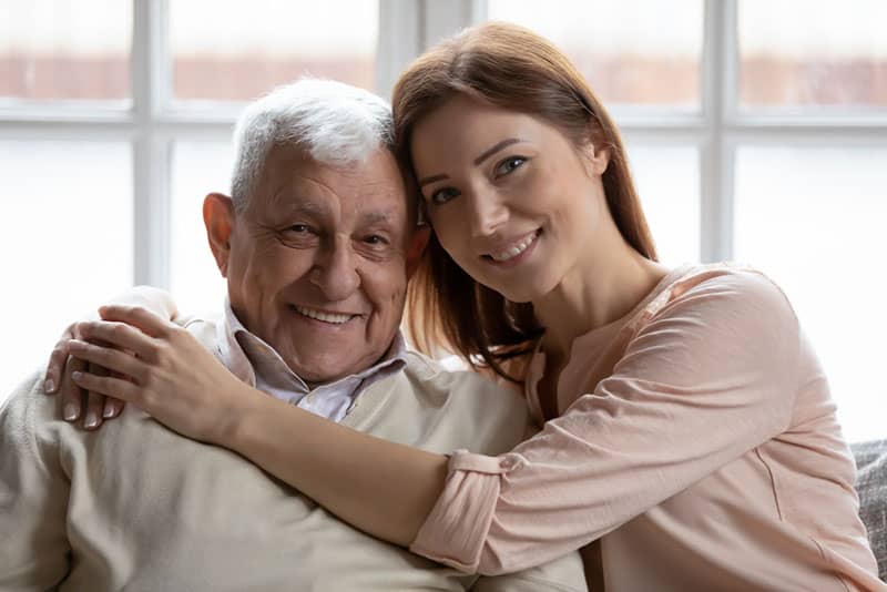 donna che abbraccia il suo vecchio padre