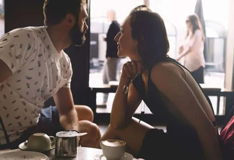 woman looking at man in cafe