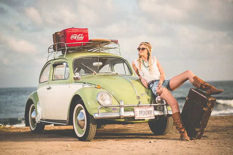 woman posing next to the car and suitcases