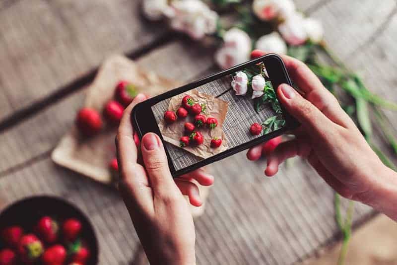 woman taking picture of vegetables