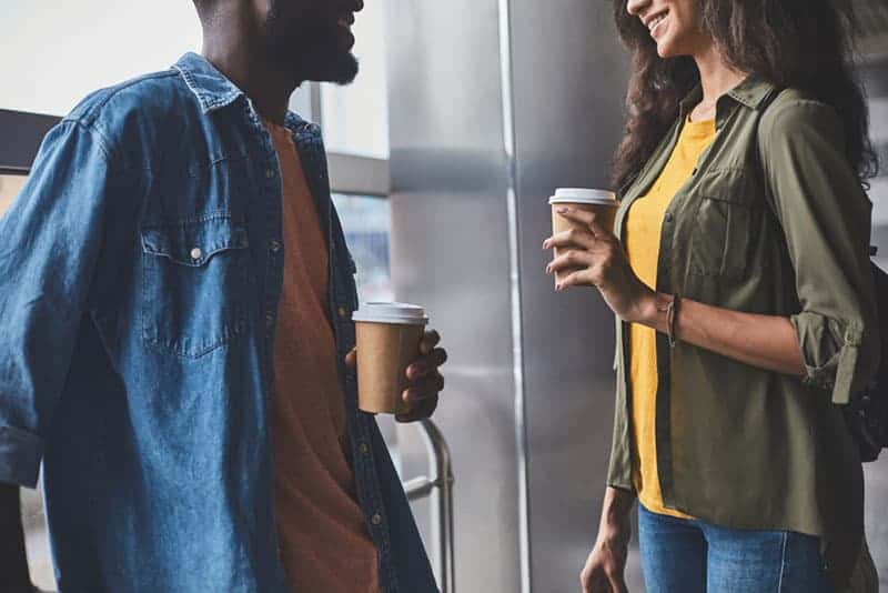 pareja joven hablando y tomando café