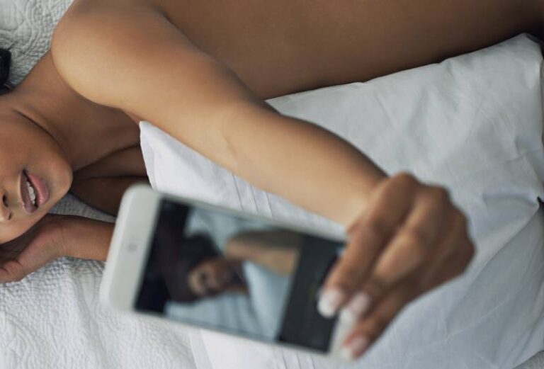 Naked woman taking a selfie