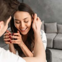 girl smiling while her man touching her hair