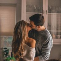 casal encantador a beijar-se em casa
