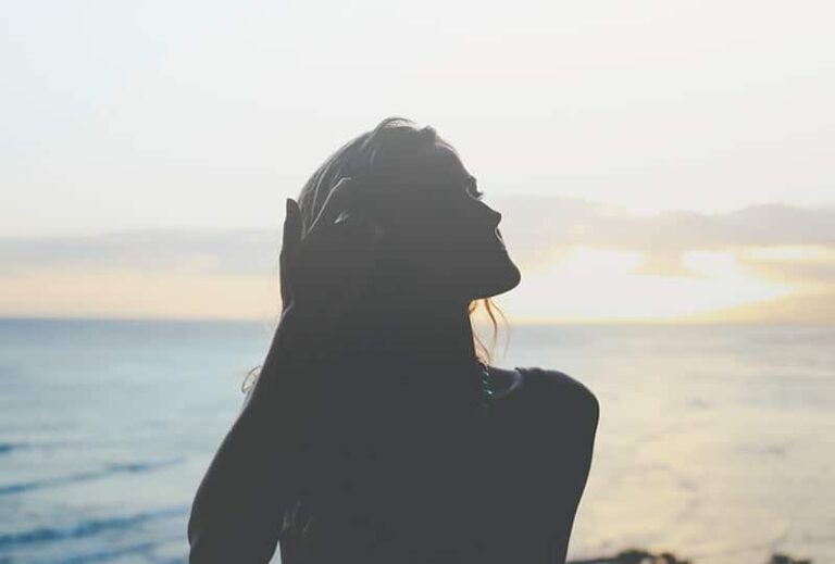 silhouette of woman beside sea