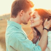 adorable pareja está a punto de besarse en el campo durante el día