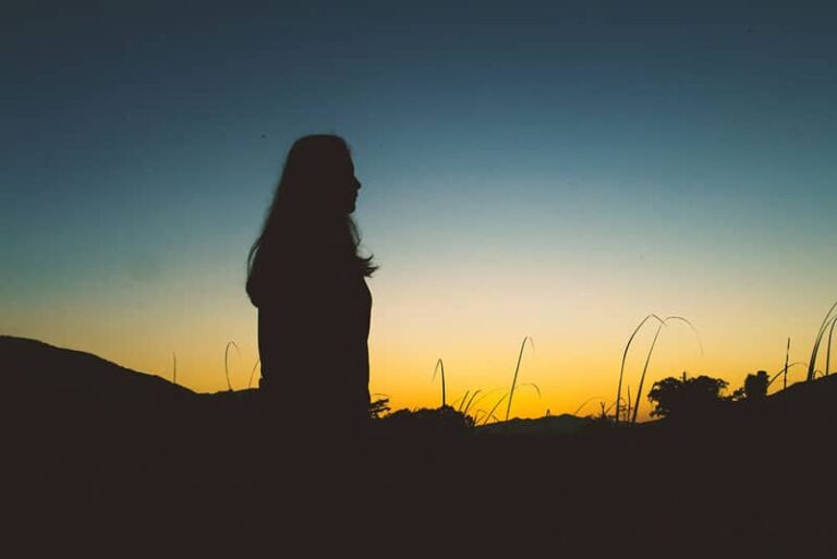 silhouette of woman standing outside during night