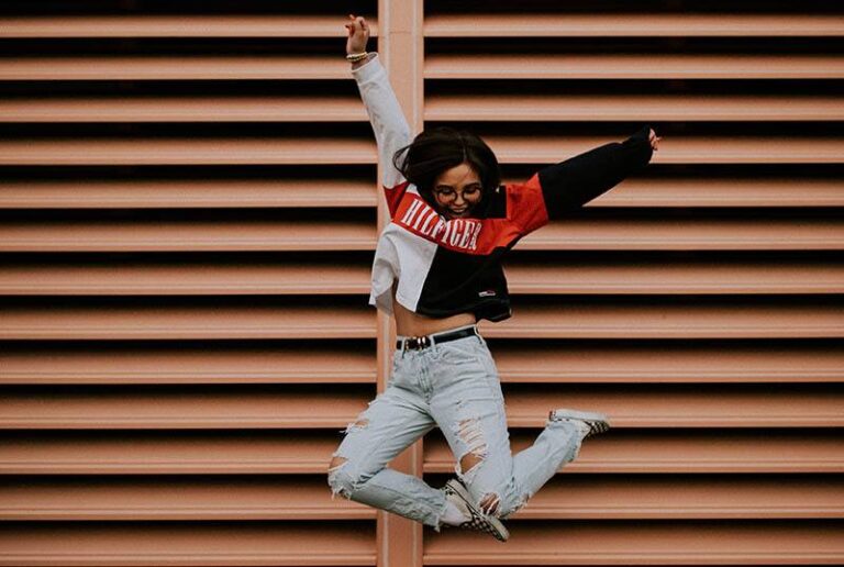 smiling woman jumping outside