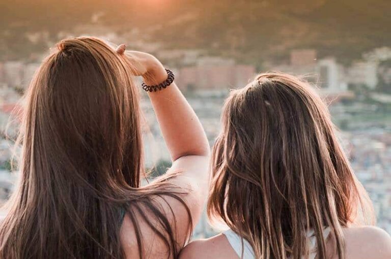back view of female friends looking at city