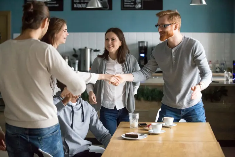 a female introducing with a group of friends in cafe