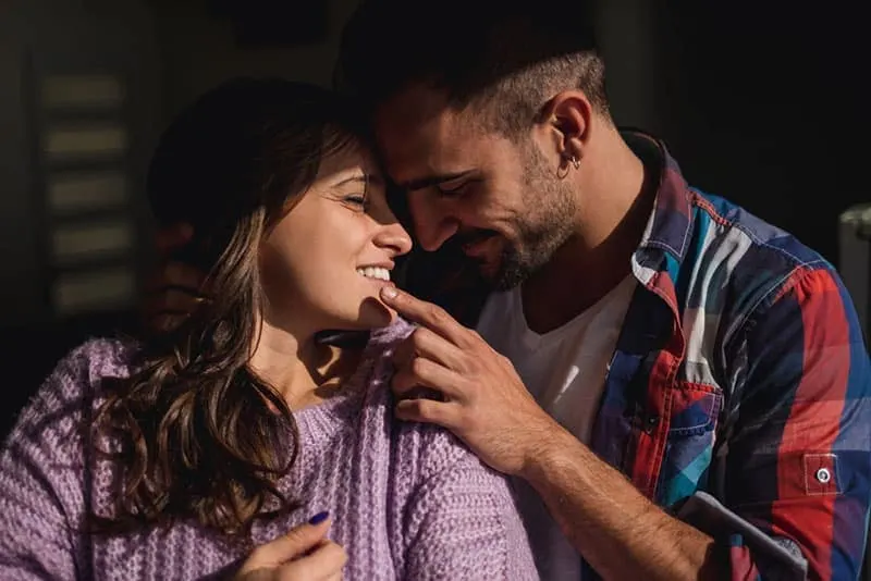 a man and a woman hugging look at each other and laugh