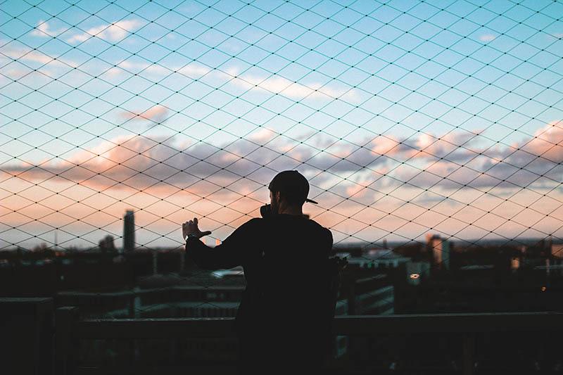 back view of man holds fence