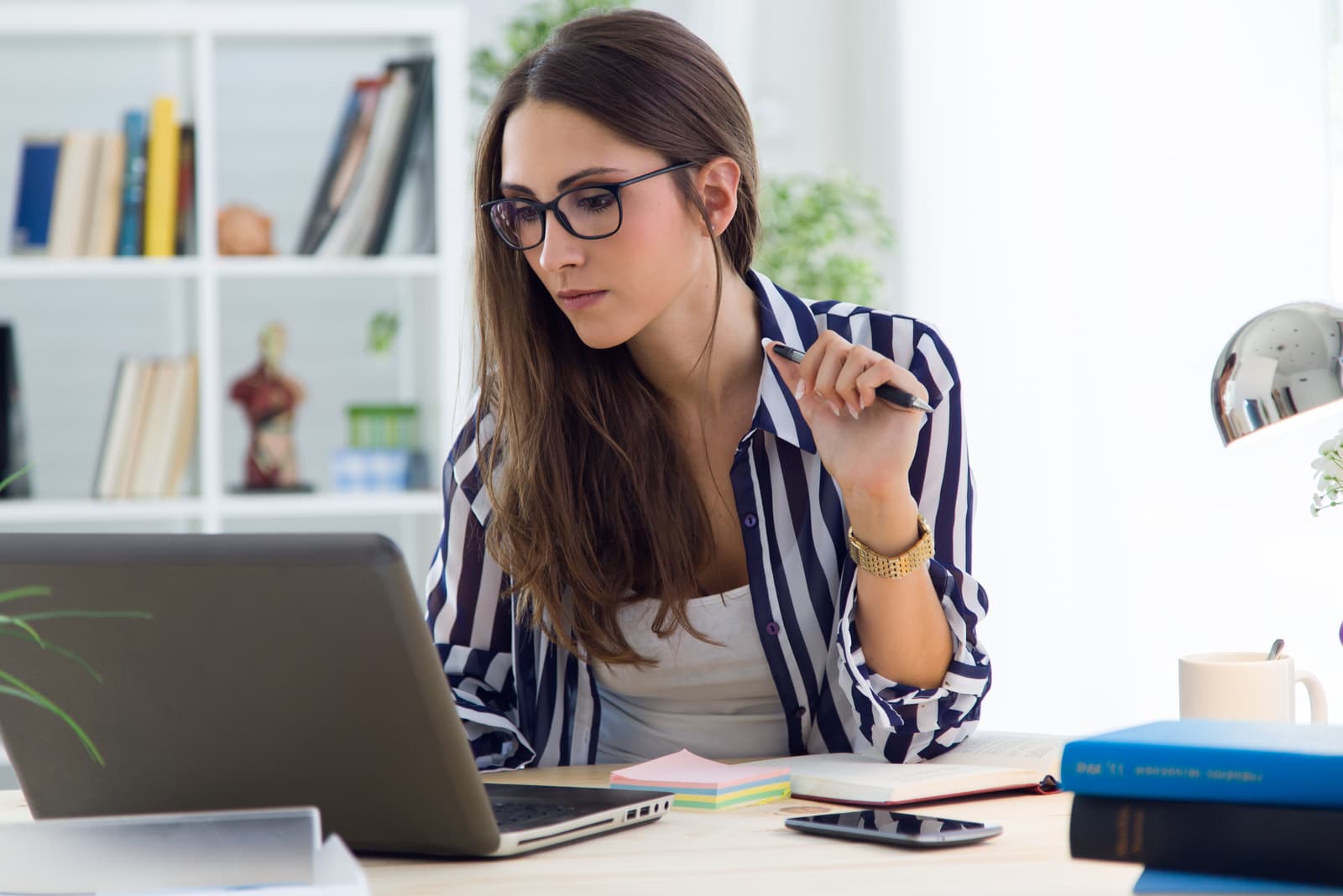 morena no escritório a trabalhar num computador portátil