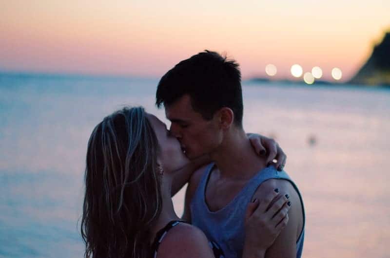 couple kissing beside sea