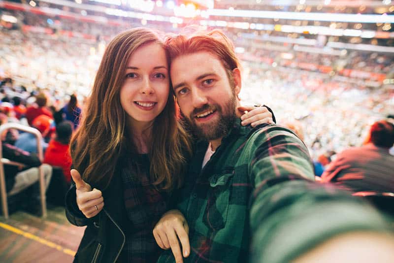 coppia che si scatta un selfie durante una partita sportiva