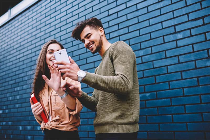 pareja feliz delante de un muro azul